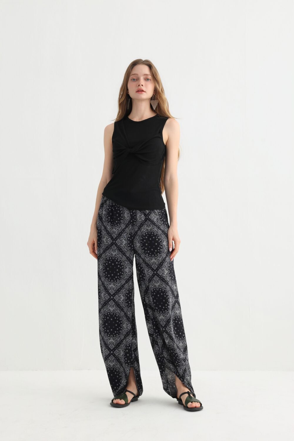Front view of black geometric split hem pants with a sleeveless top