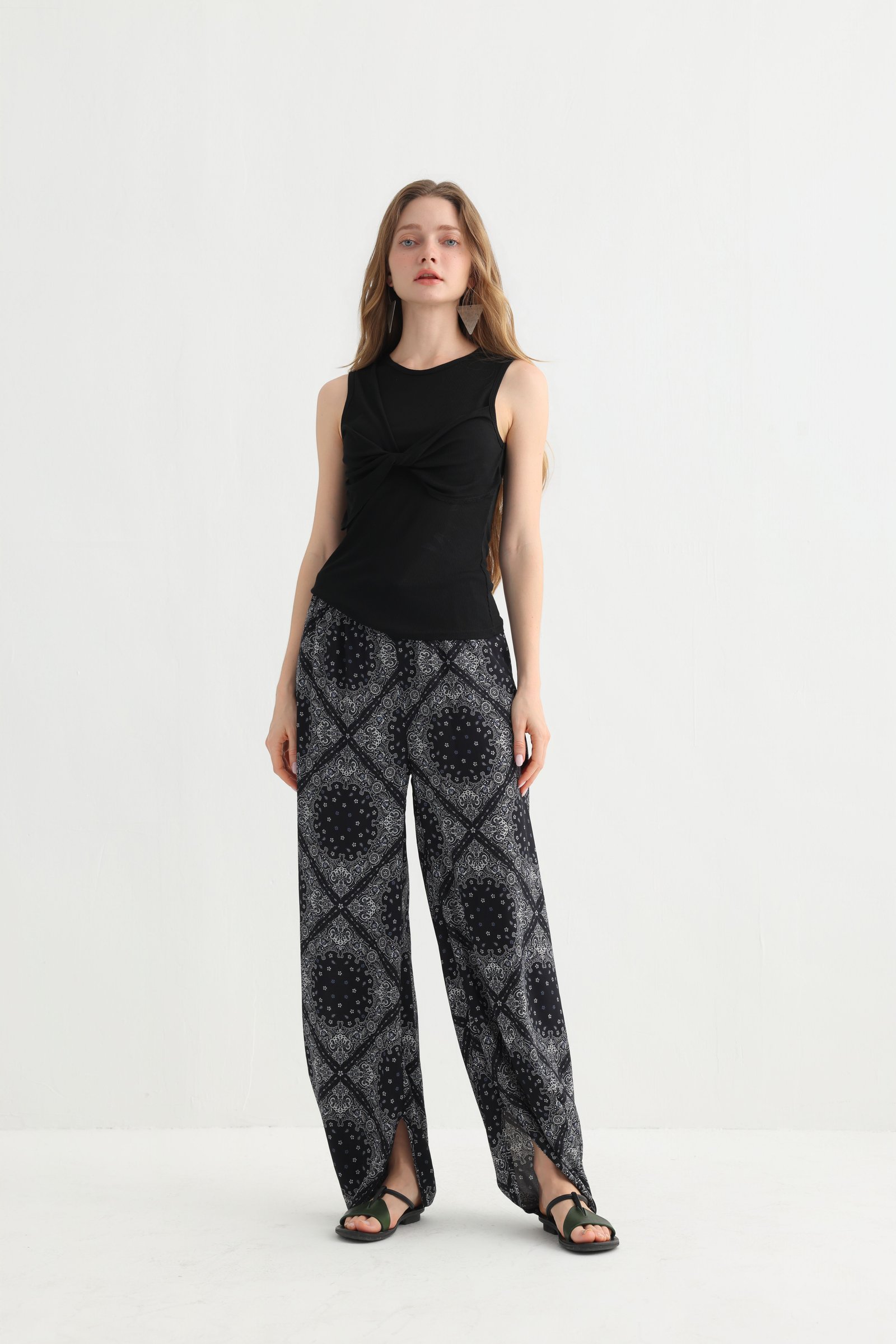 Front view of black geometric split hem pants with a sleeveless top