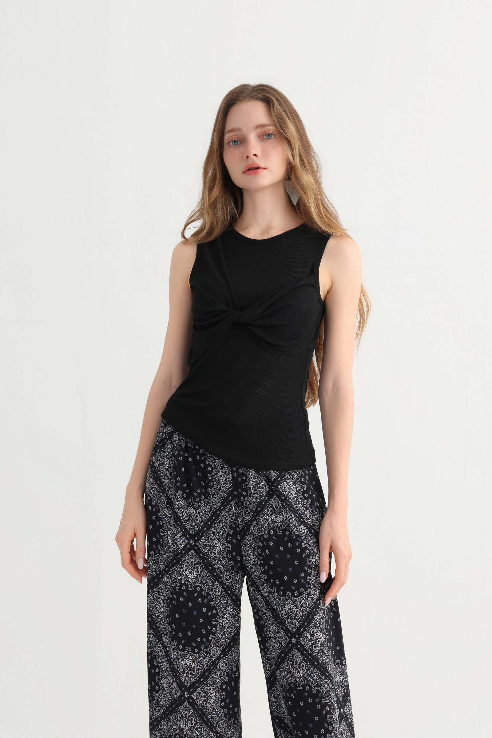 Styling detail of the black sleeveless top worn with geometric pants