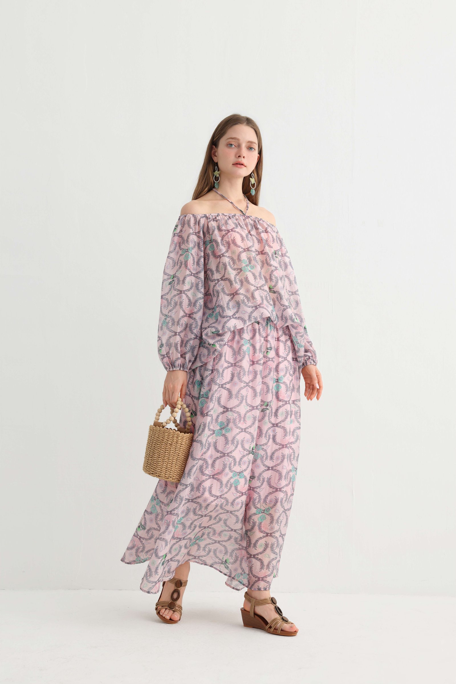 Model carrying a straw bag in the floral vacation set
