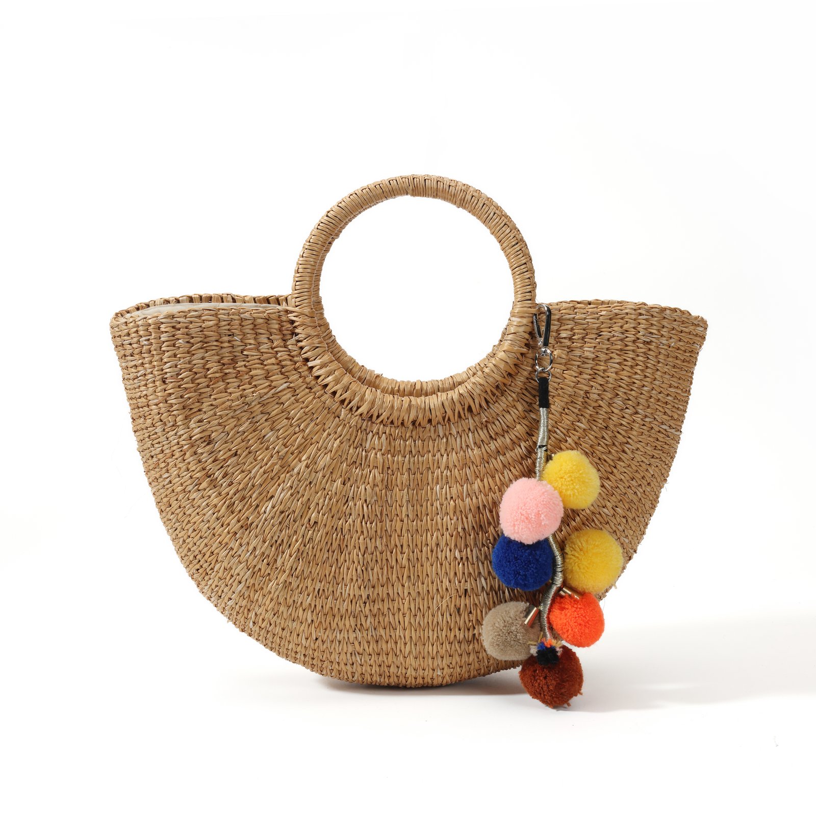 Pom pom straw tote bag with half-moon shape and colorful clustered charms