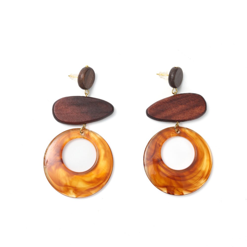 Close-up of amber resin and wood drop earrings with large marbled rings