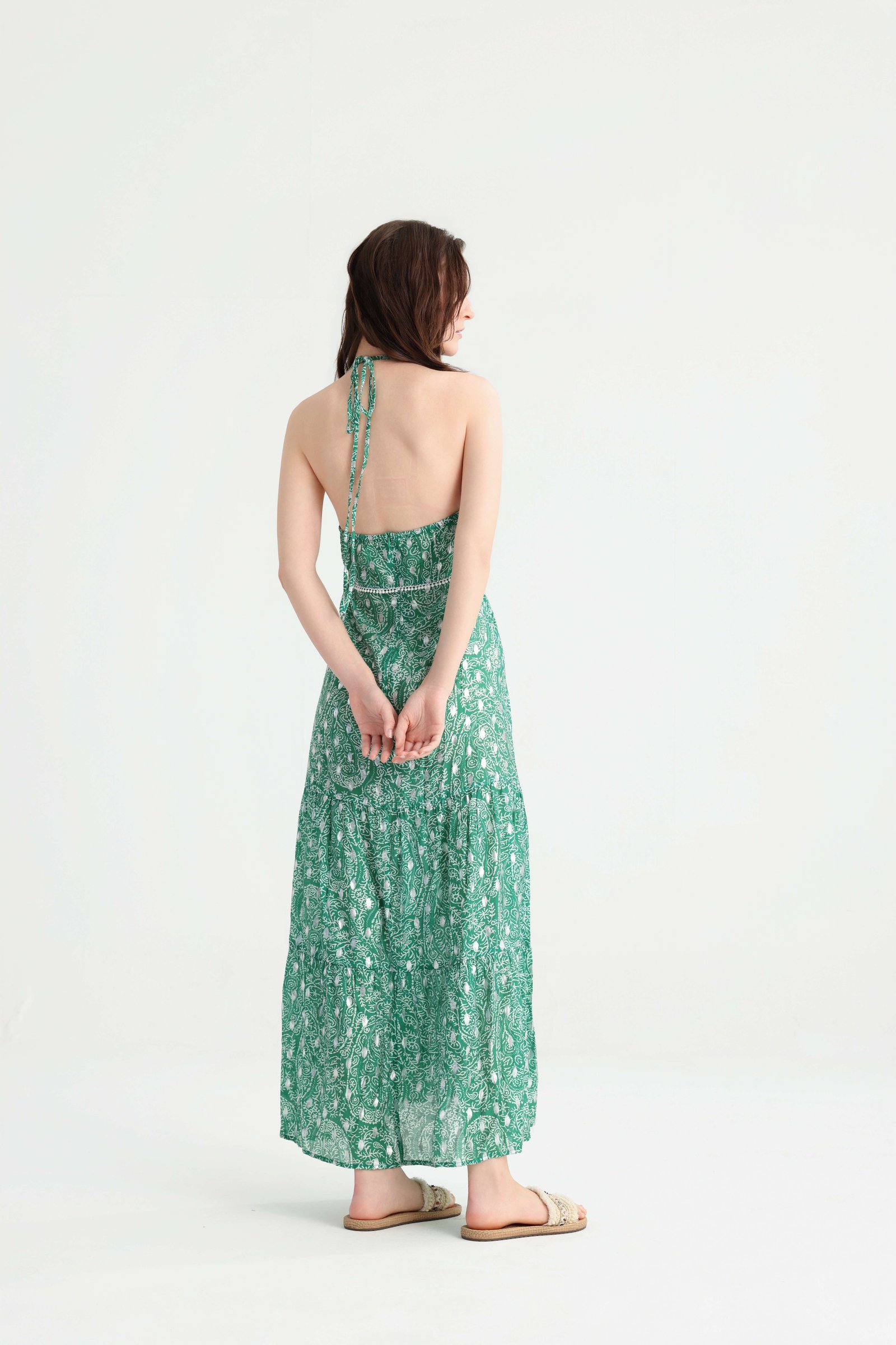 Back view of the green printed halter tiered maxi dress