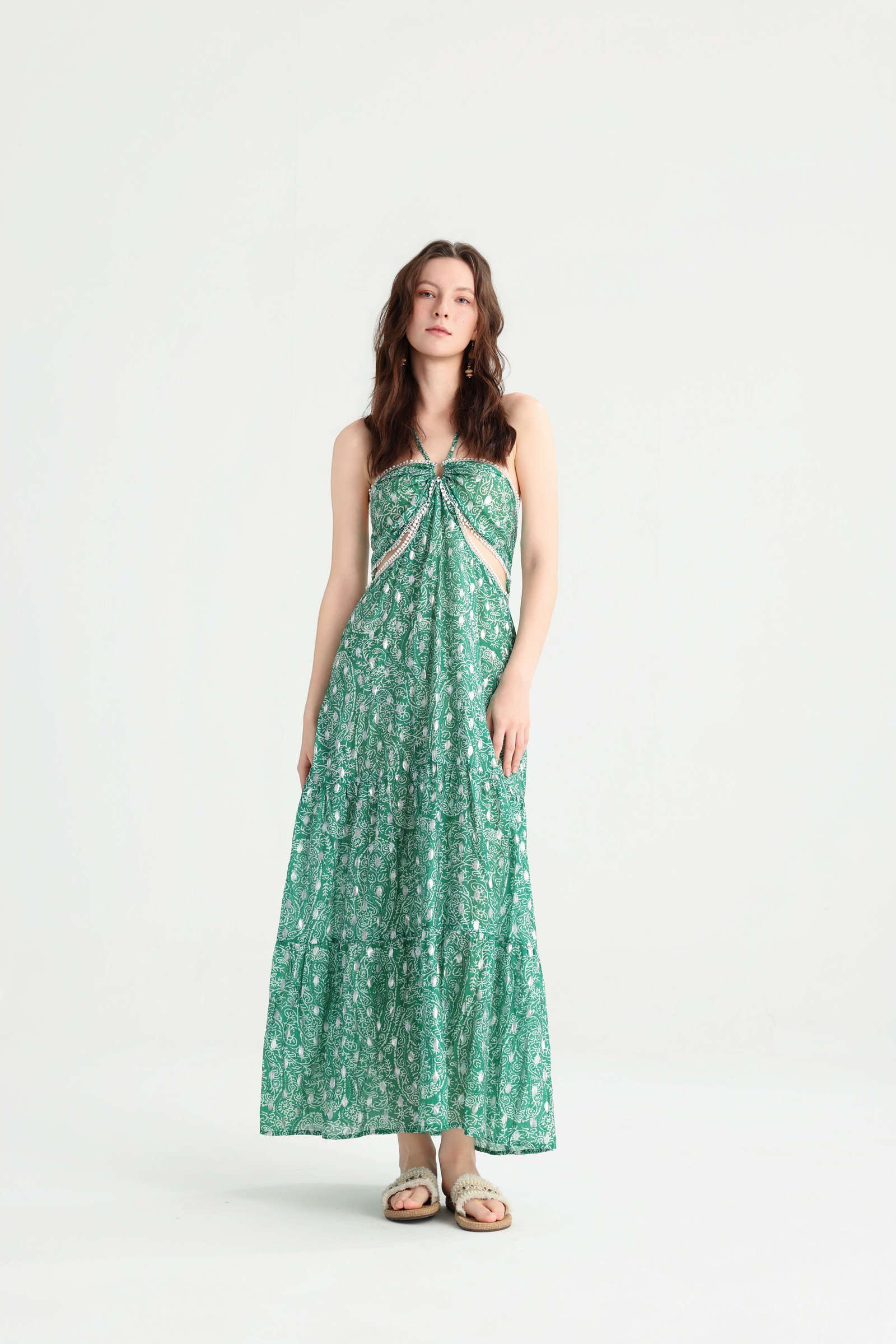 Front view of a green paisley tiered maxi dress with waist cutouts