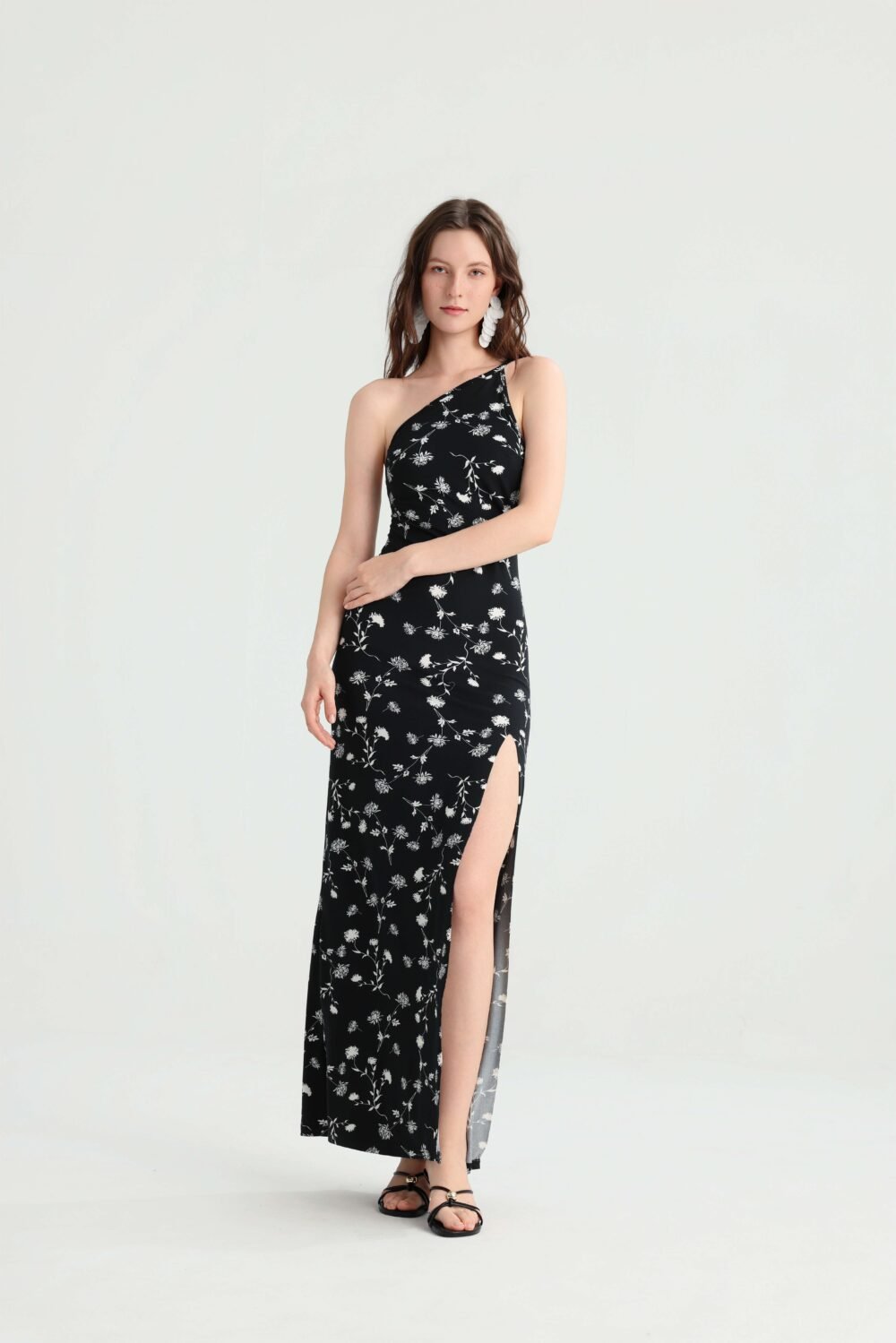 Model wearing the black and white ditsy floral maxi dress with one arm across her waist