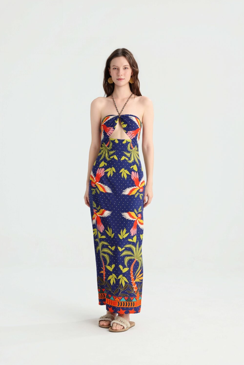 Front view of a navy tropical bird print halter cutout maxi dress