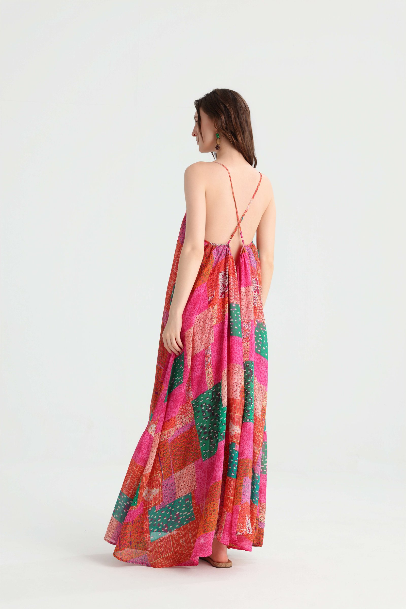 Back view of the pink patchwork maxi dress showing crossed spaghetti straps and a low open back