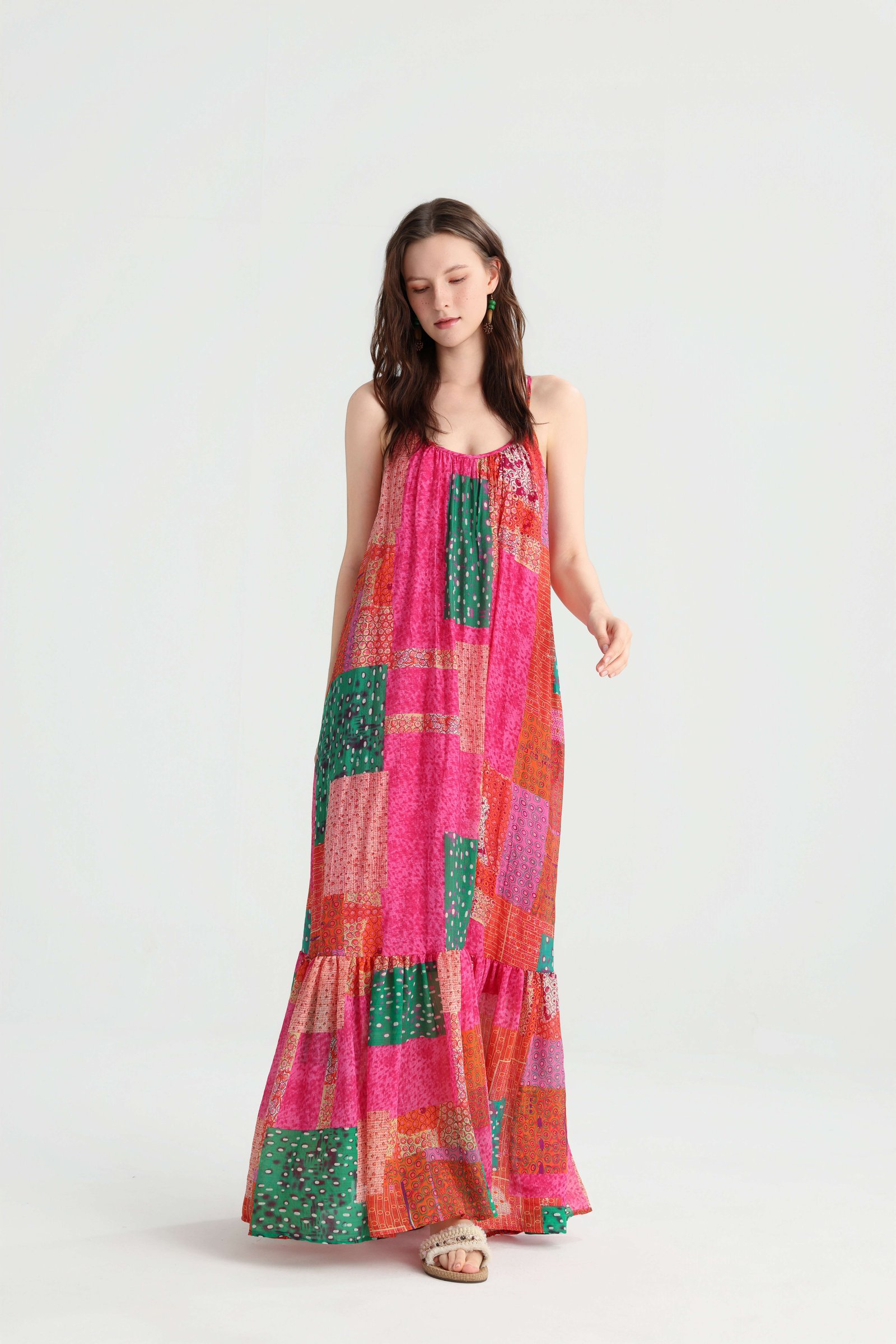 Front view of the loose patchwork maxi dress showing the gathered lower tier and flat sandals