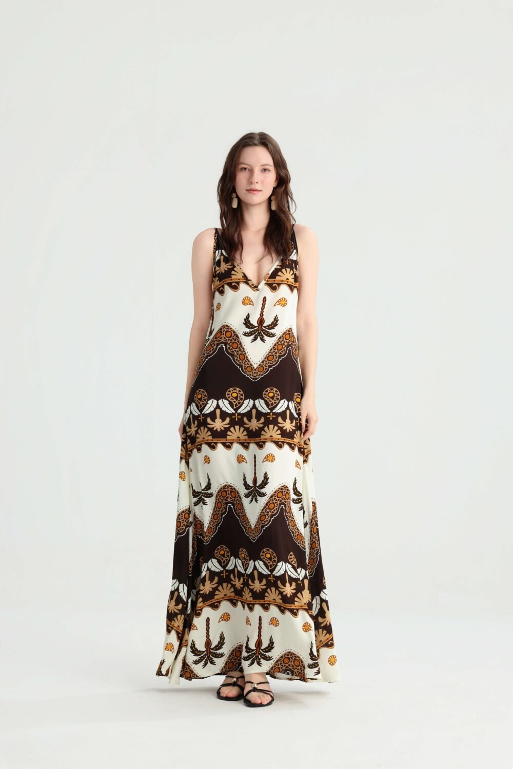 Front view of a brown and ivory boho print spaghetti strap maxi dress with an A-line silhouette