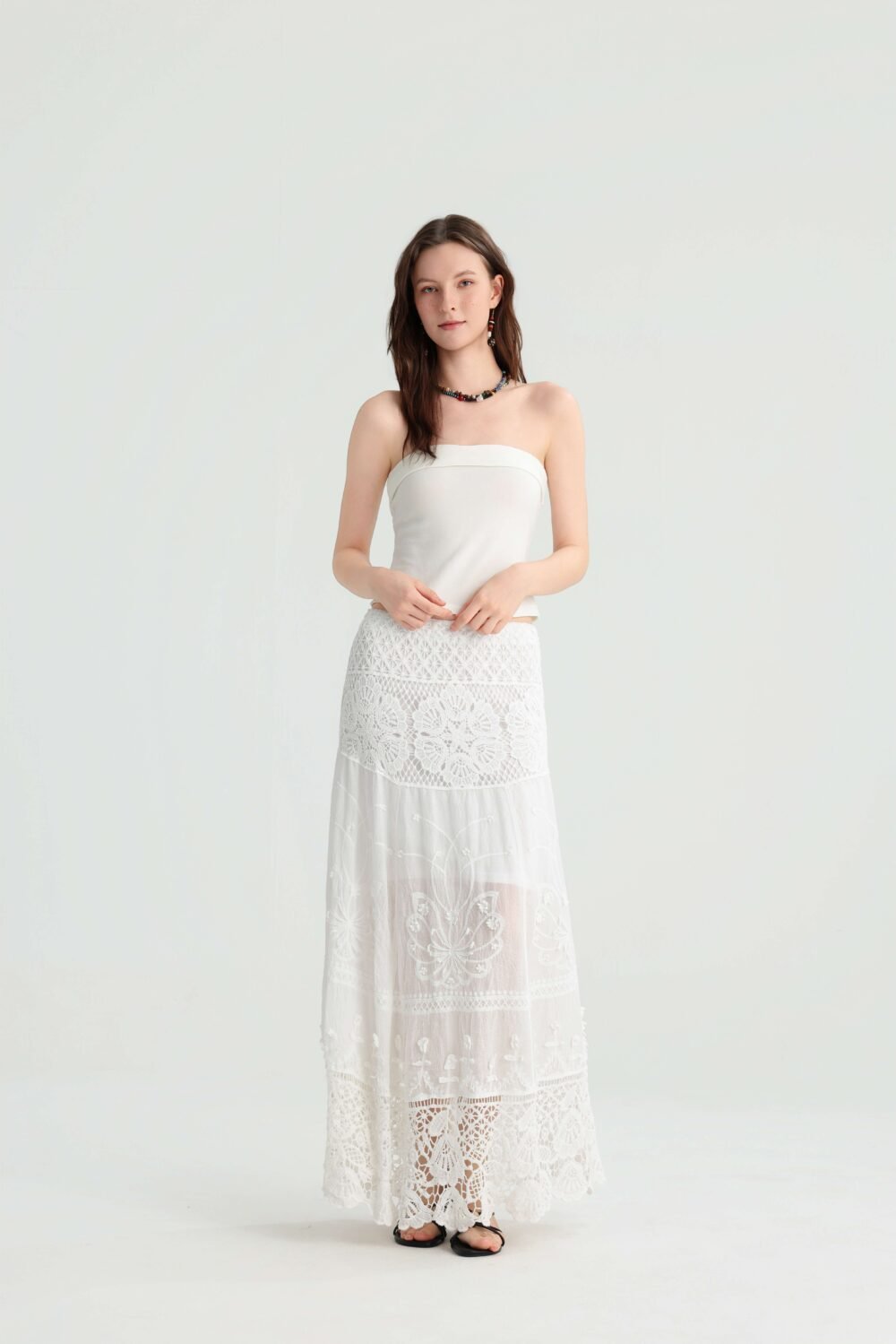 Full-length front view of an ivory bandeau top and lace maxi skirt outfit